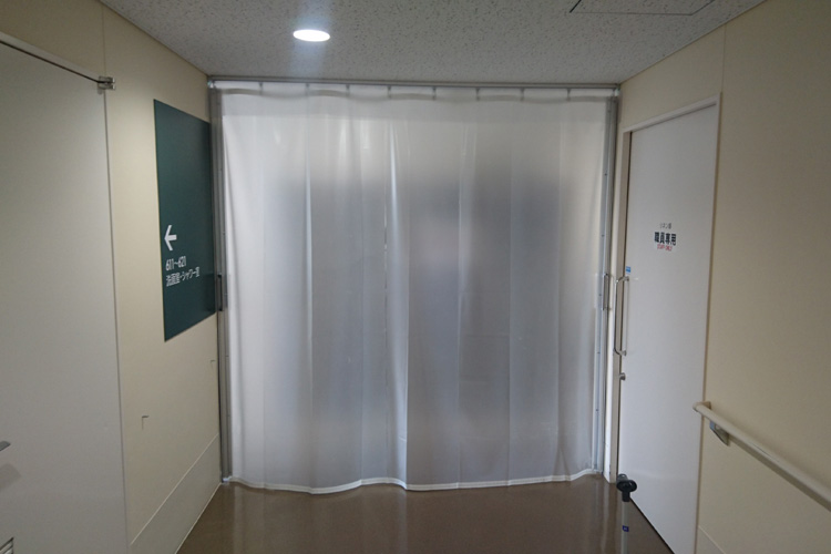 感染症対策とプライバシー保護のため、病院内通路に半透明ビニールカーテンを設置