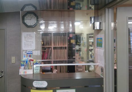受付カウンターの飛沫感染対策に透明ロールスクリーンを設置