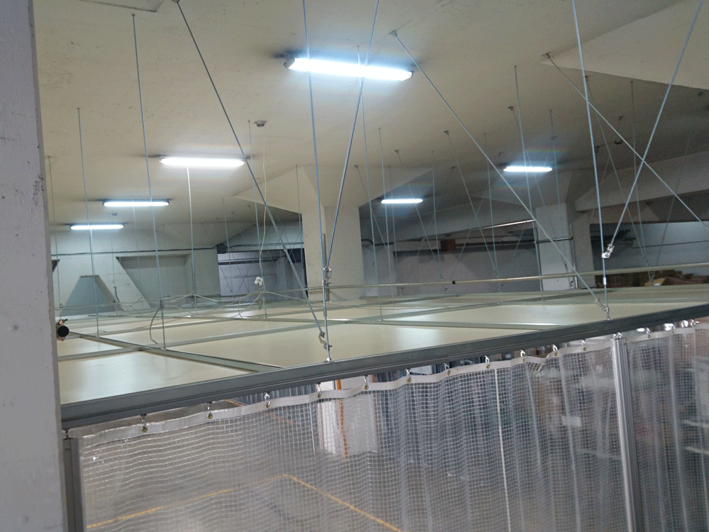 吊り天井と周囲の糸入りビニールカーテンの設置で作業場のみ空調効率が上がるよう施工