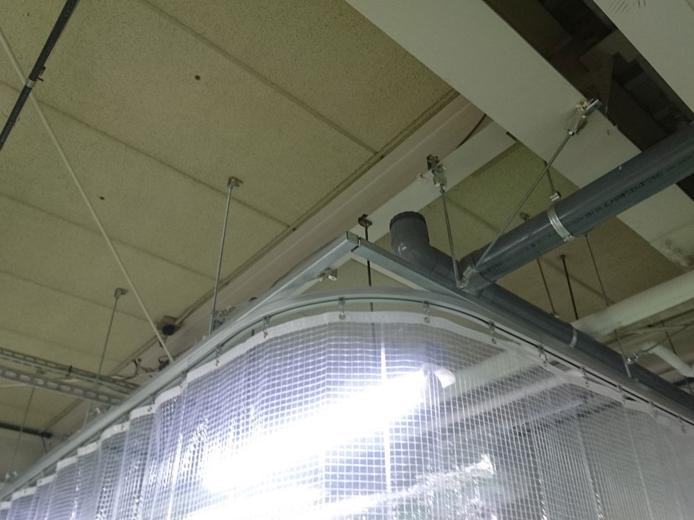 障害物の多い工場の天井には吊金具を使用してカーテンレールを設置