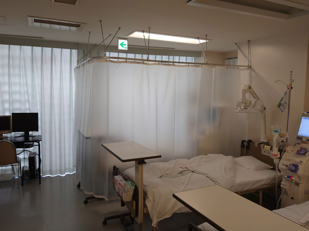 病院内個室のベッド周辺に感染症対策に半透明梨地ビニールカーテンを設置