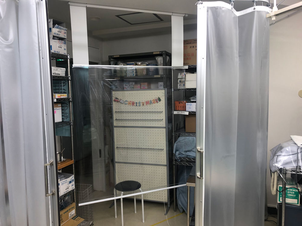 PCR検査のため飛沫対策の透明ロールスクリーンとプライバシー保護のための半透明ビニールカーテンを設置