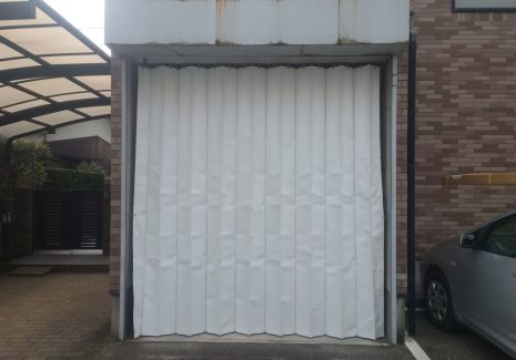 新型コロナウイルス検査用スペースを病院敷地内に仮設するため倉庫にパタパタビニールカーテンを設置