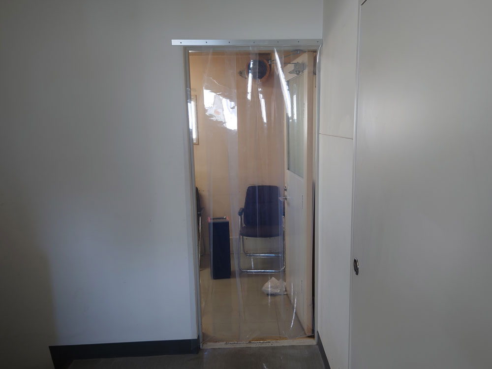 オフィスの喫煙室出入口にのれんカーテンを設置。下に隙間を作って流入風を確保