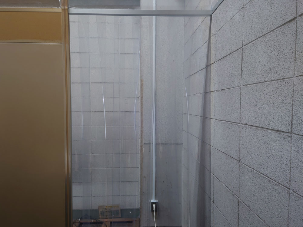 喫煙室出入口ののれんカーテンは厚さ1mmのビニールシートをのれん状に加工してアルミ角材に固定してあり出入りもしやすい