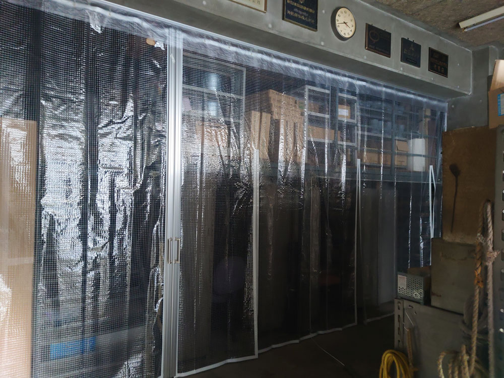 倉庫内の間仕切りに糸入り透明ビニールカーテンを設置