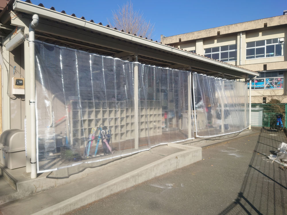 児童クラブの屋外通路の雨よけに糸入り透明ビニールカーテン