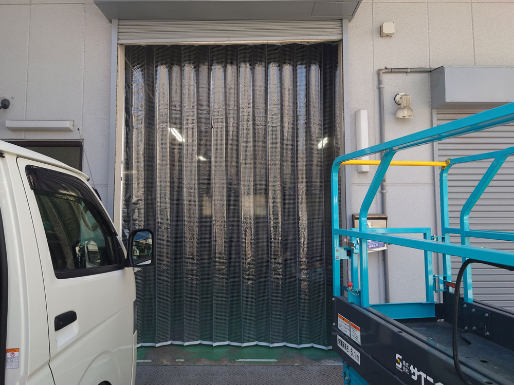 倉庫出入口のシャッター内側に糸入り透明パタパタビニールカーテンを設置
