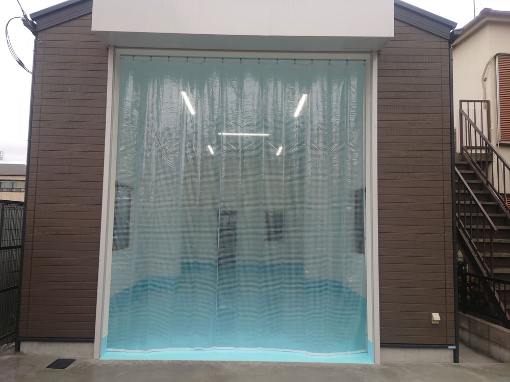 新たにオープンするカーショップ作業場の出入口に埃や雨の侵入防止のためのビニールカーテンを設置