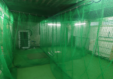 屋内野球練習場に練習スペースを区切るための防球ネットを接地