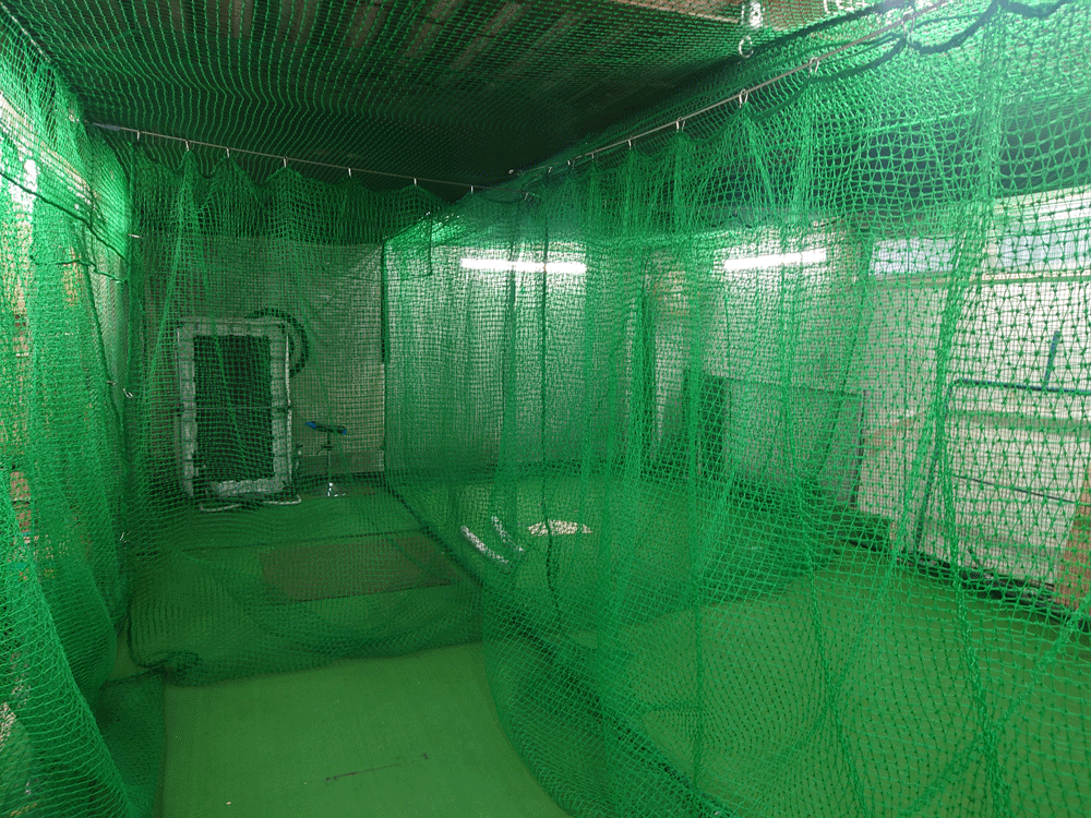 屋内野球練習場に練習スペースを区切るための防球ネットを接地