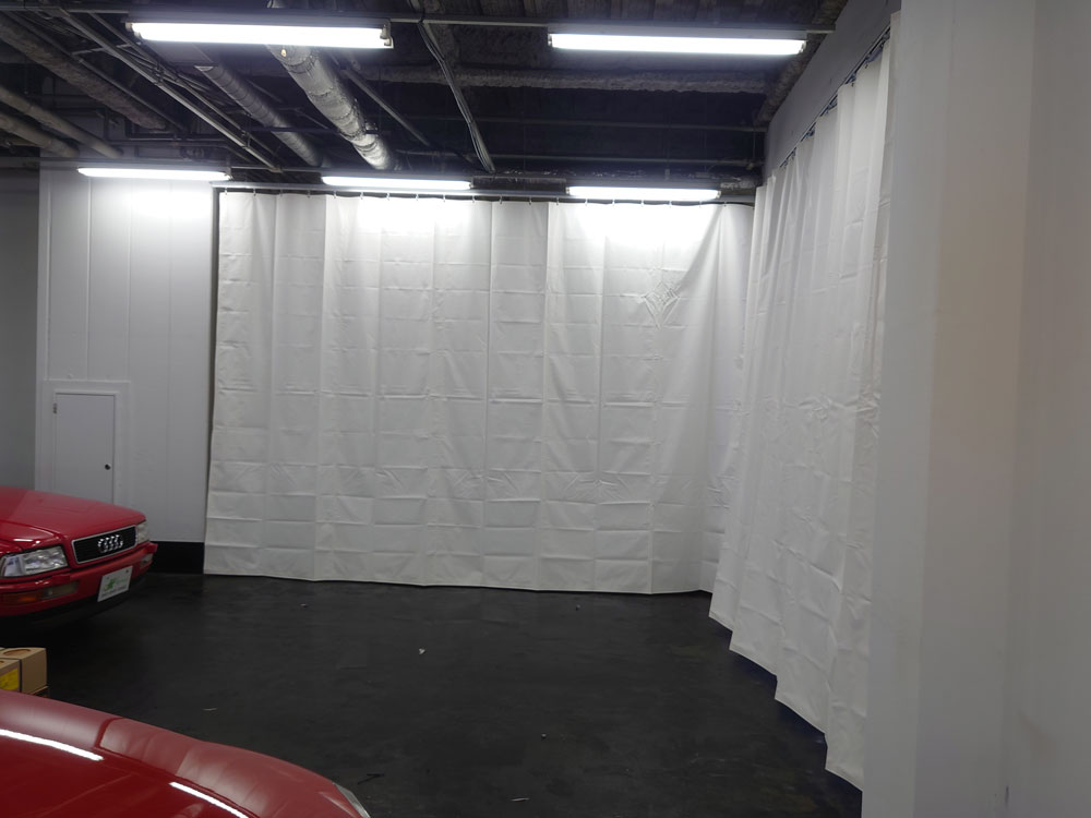 プロジェクターで映像を投影するためにホワイトのビニールカーテンを設置。たたみジワは数日で伸びて消えていきます