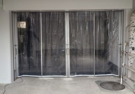 会社の駐車場出入口に埃よけ・防寒のための糸入り透明ビニールカーテンを設置