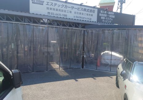 高級車を扱う自動車整備工場出入口のエアコン省エネ対策にビニールカーテンを設置