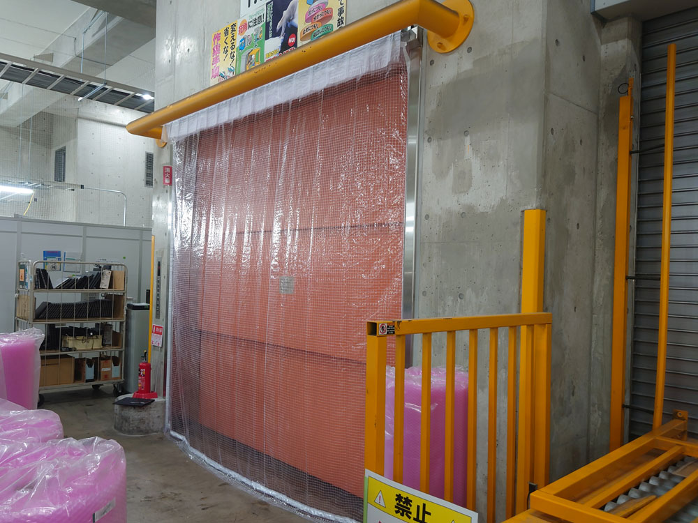 エレベーターの扉の隙間から倉庫内へ吹き込む冷気を防ぐためのビニールカーテンを設置しました
