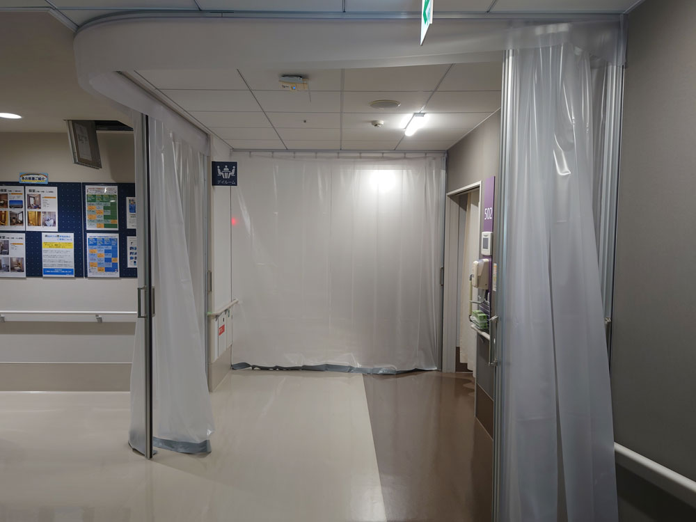 新型コロナウイルス感染症の患者受け入れが決まった病院の動線分離のための間仕切として半透明ビニールカーテンを設置しました