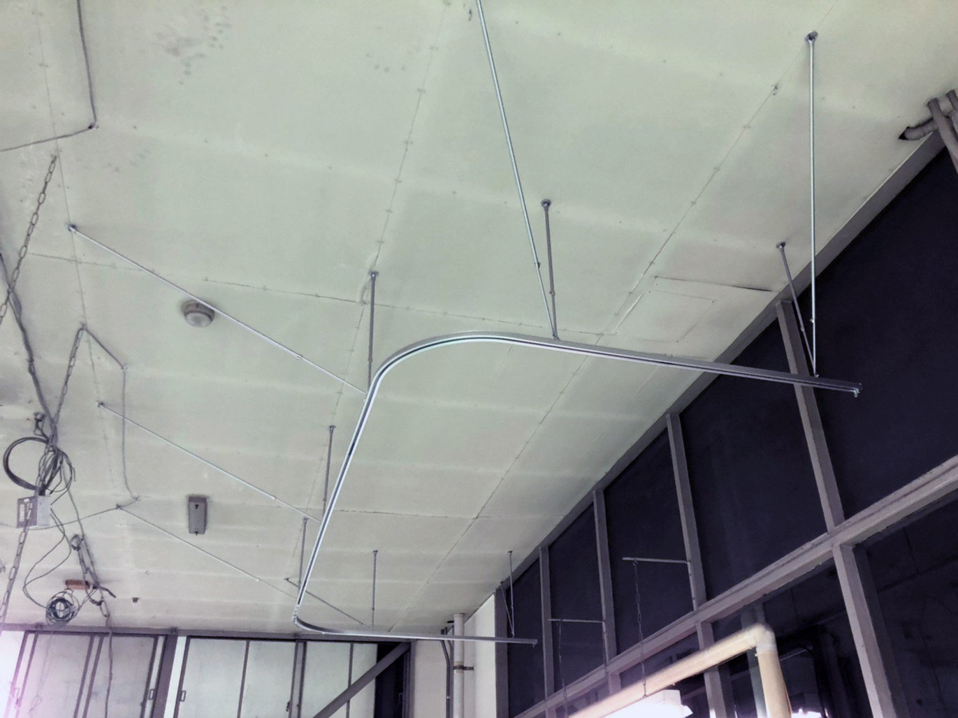 こちらも吊り棒を使用して天井との間を空けてカーテンレールを設置しています